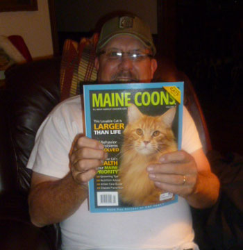 Daddy holds his copy of Cat Fancy magazine dedicated to Maine Coons.